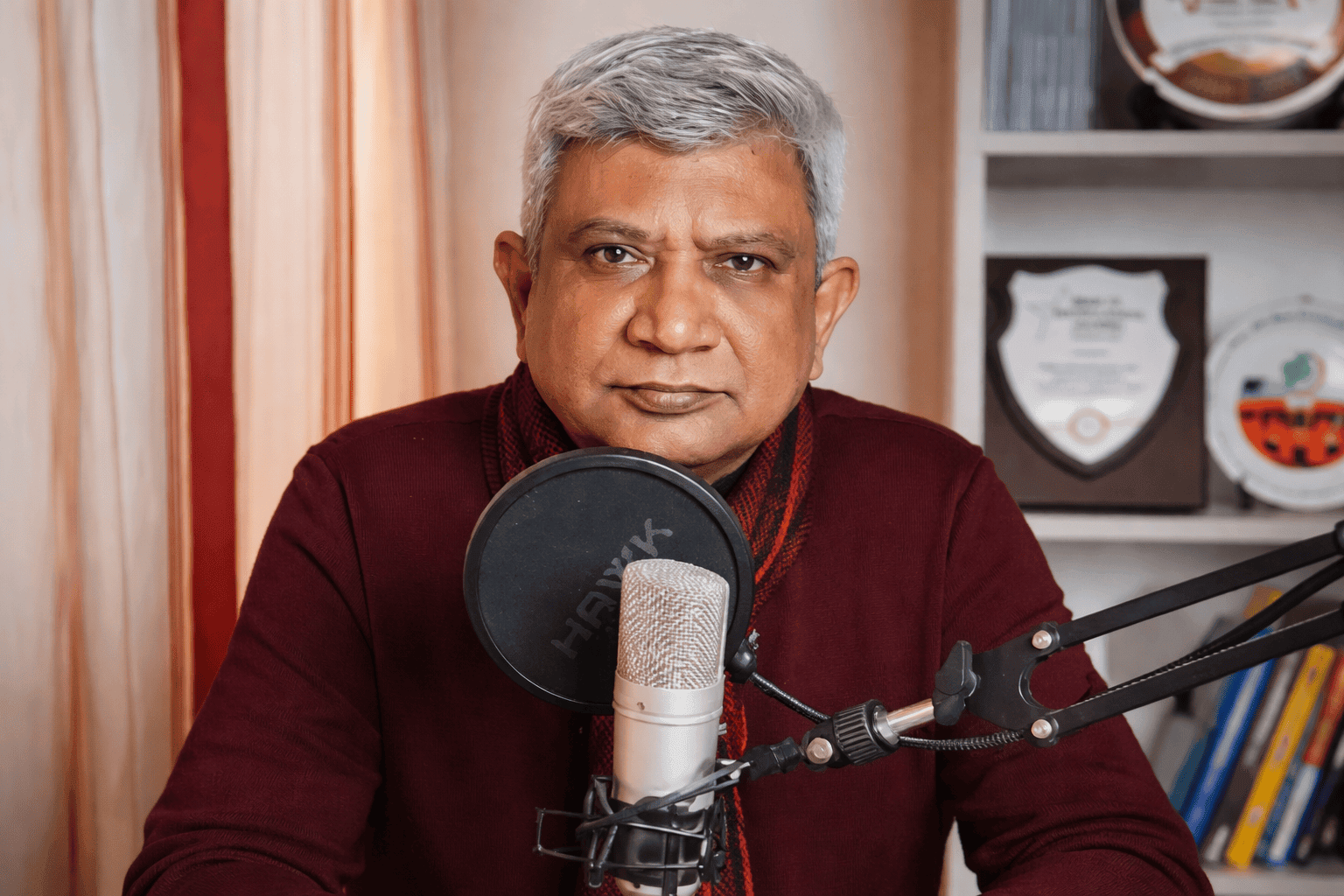Himadri S. De speaking into a podcast microphone